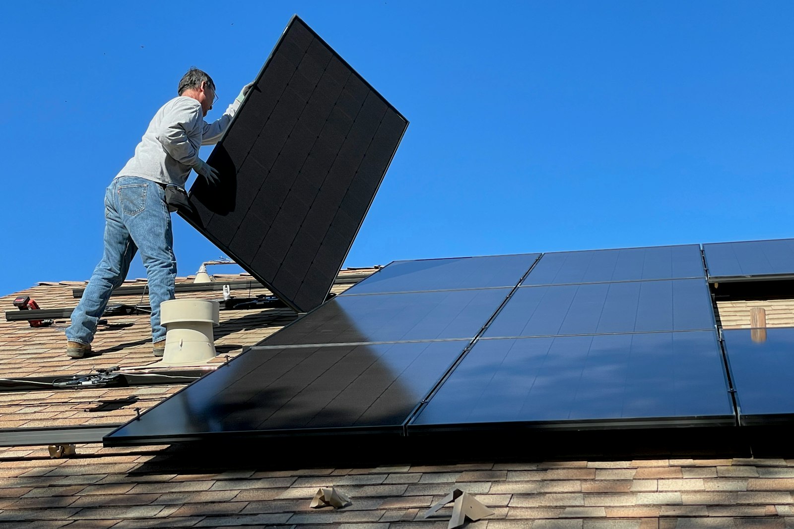 Montör installerar solpanel på ett tegeltak